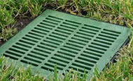 Green metal French drain grate installed by drainage pros